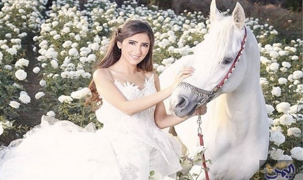 بفستان زفاف.. مي عمر في جلسة تصوير رومانسية مع حصان أبيض