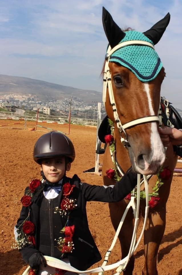 بالصور.. حصان أبيض هدية من الرئيس الفلسطيني للفارس الناجي من حريق قرية الدوما